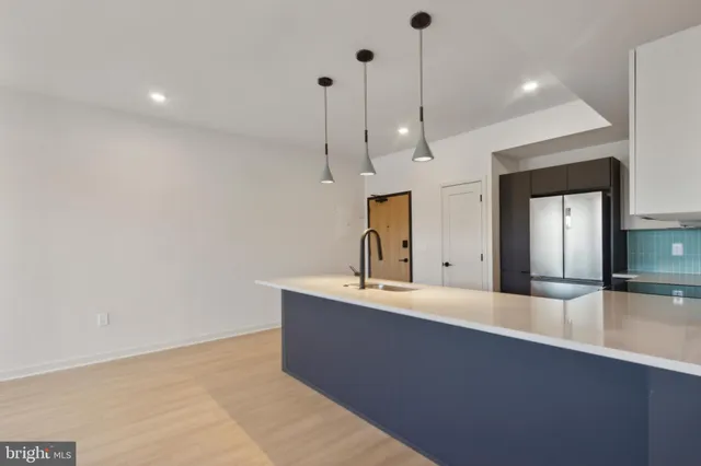 a kitchen with stainless steel appliances granite countertop a sink a stove a refrigerator cabinets and a window