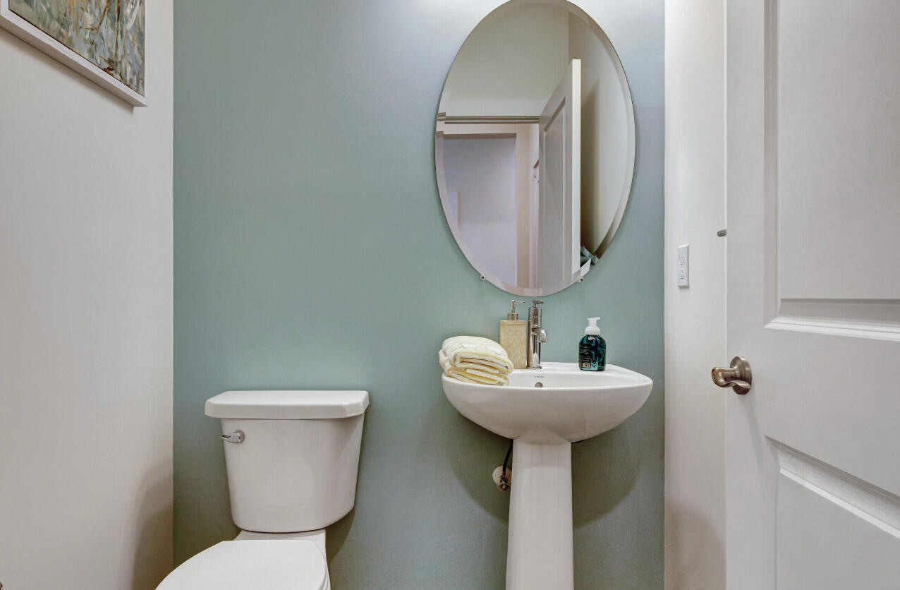 608 Waters Edge Lane, Unit 2202 Port St. Lucie, FL 34983 - Photo 11 of 19 a bathroom with a toilet sink and mirror