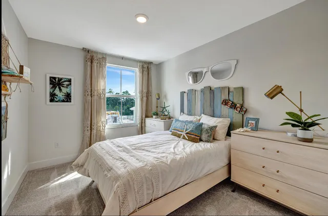 a bedroom with a bed and large windows