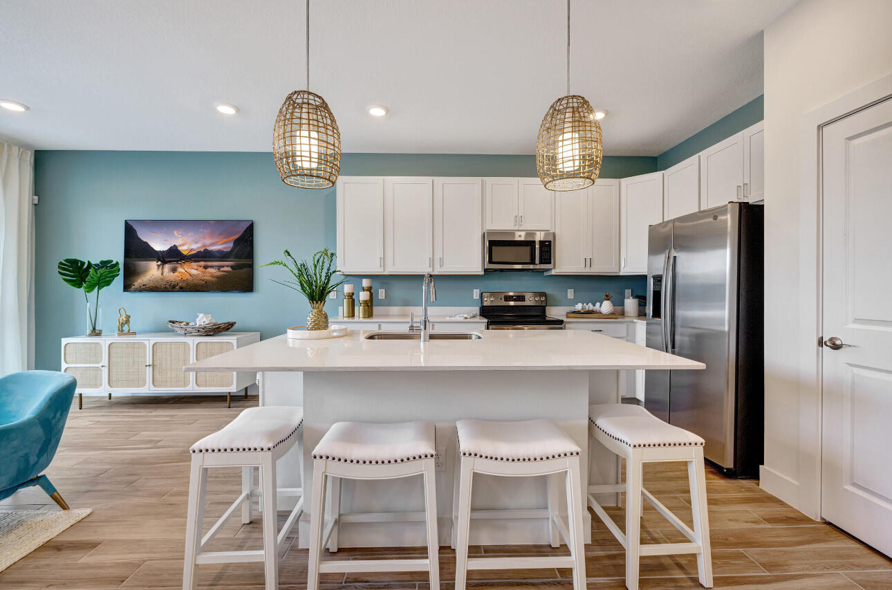 608 Waters Edge Lane, Unit 2202 Port St. Lucie, FL 34983 - Photo 2 of 19 a kitchen with stainless steel appliances granite countertop a sink a stove a refrigerator cabinets a dining table and chairs