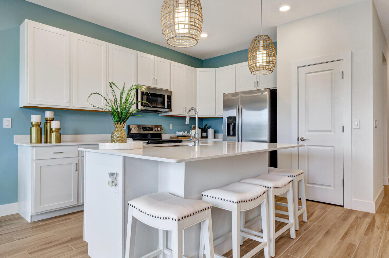 608 Waters Edge Lane, Unit 2202 Port St. Lucie, FL 34983 - Photo 3 of 19 a kitchen with a white cabinets and chairs