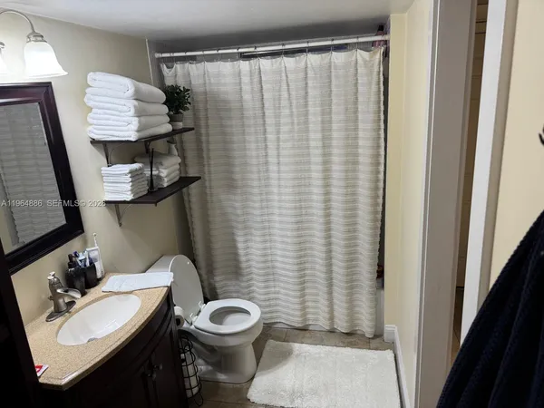 a bathroom with a sink a toilet and shower curtain
