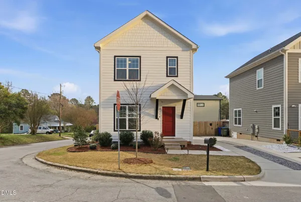 a front view of house with yard and trees in the background