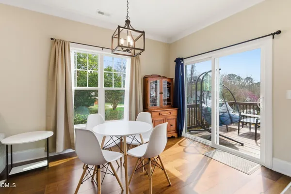 a kitchen with a refrigerator a microwave a stove and white cabinets with wooden floor