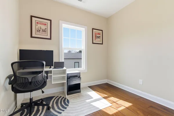 a bedroom with a bed and hardwood floor