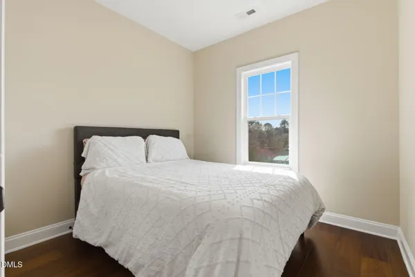 a bedroom with a large bed and a window