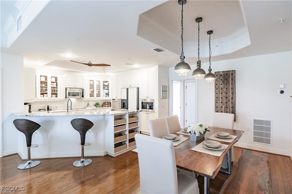 572 11th Avenue South, Unit 2 Naples, FL 34102 - Photo 3 of 28 a living room with furniture a chandelier and a table
