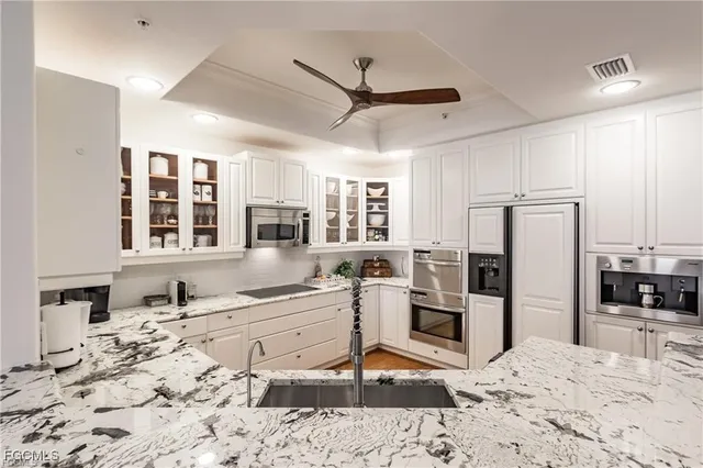 a kitchen with stainless steel appliances kitchen island granite countertop a refrigerator and a stove top oven