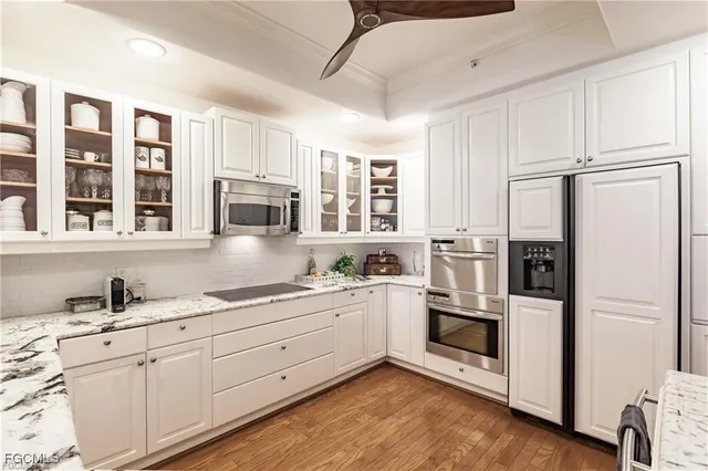 a kitchen with stainless steel appliances white cabinets and wooden floors