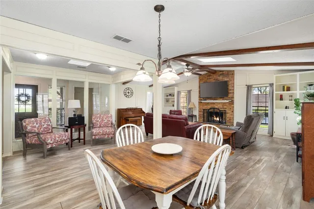a view of a dining room with furniture a chandelier and wooden floor