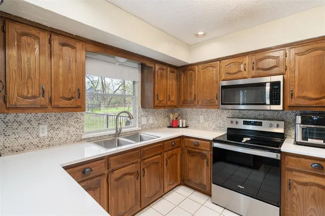a kitchen with stainless steel appliances granite countertop a sink stove microwave and cabinets