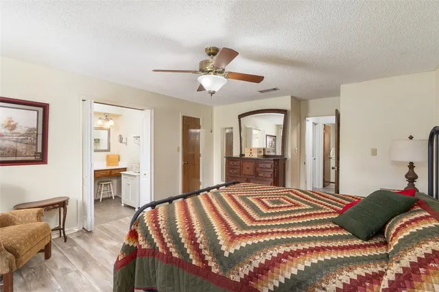 a bedroom with a large bed and a chandelier