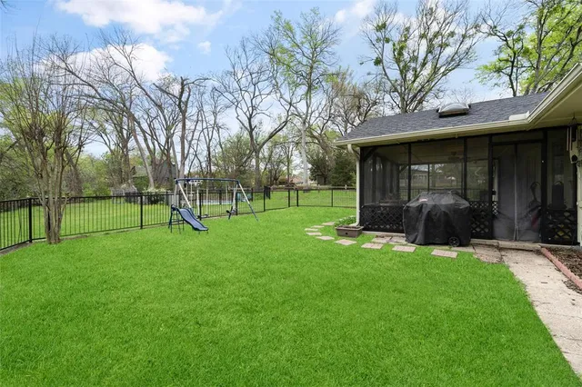 a view of a house with backyard and a tree
