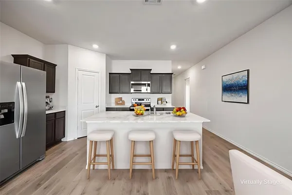 a kitchen with refrigerator cabinets and wooden floor