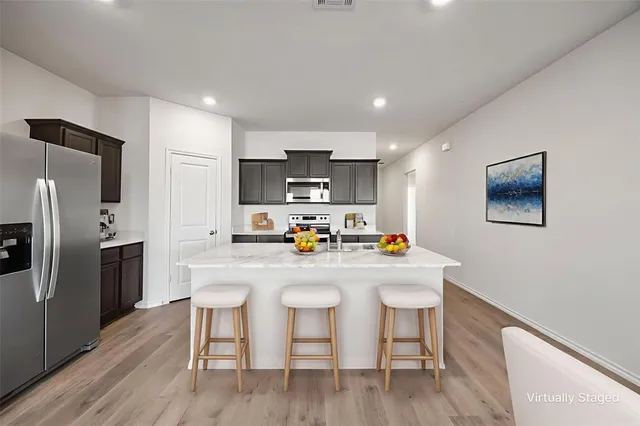 a kitchen with refrigerator cabinets and wooden floor