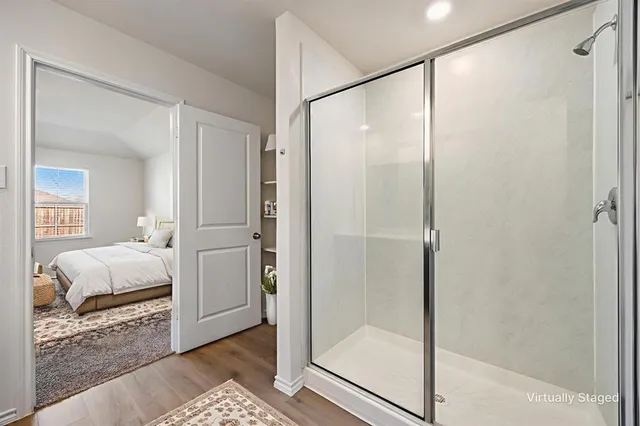 a bathroom with a glass shower door and a walk in closet