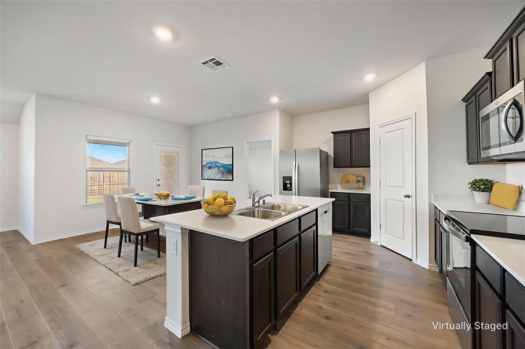 2811 Jasmine Drive Sherman, TX 75092 - Photo 8 of 22 a kitchen with stainless steel appliances a sink a stove a refrigerator cabinets and a dining table