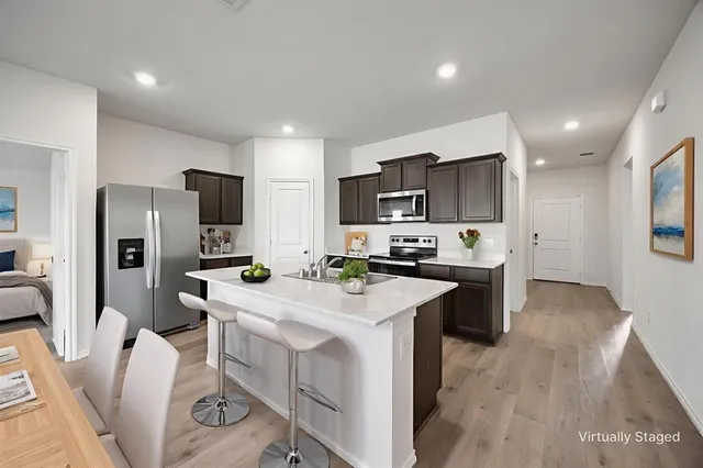 a kitchen with a sink a counter top space stainless steel appliances and cabinets