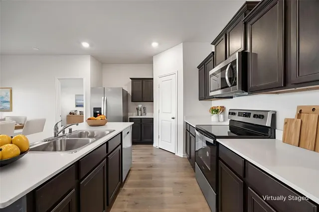 a kitchen with granite countertop a sink counter top space appliances and cabinets
