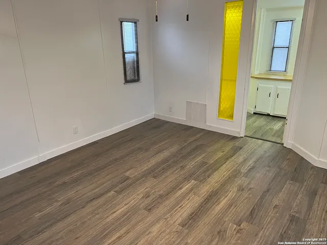 a view of a room with wooden floor and a window
