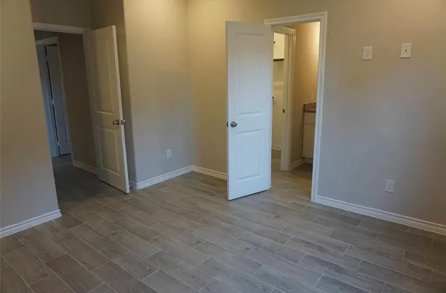 an empty room with wooden floor and closet
