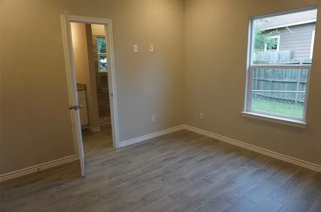 an empty room with wooden floor and a window