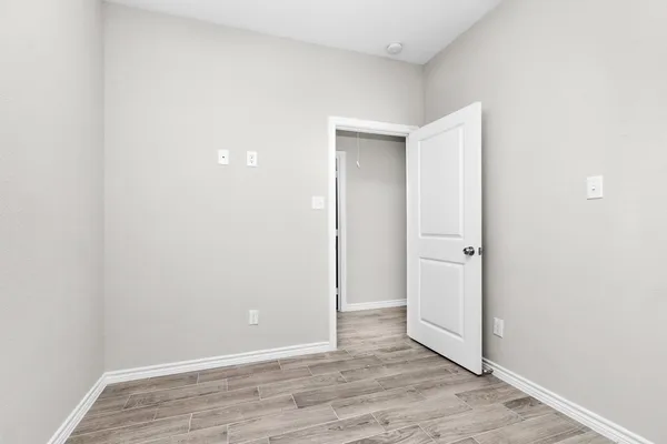 a view of an empty room with wooden floor