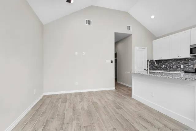 a view of kitchen with a sink and dishwasher a refrigerator with wooden floor