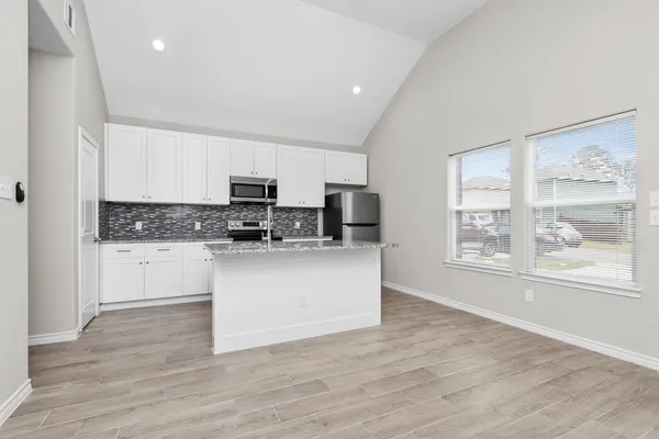 a kitchen with stainless steel appliances granite countertop a stove a sink and a microwave