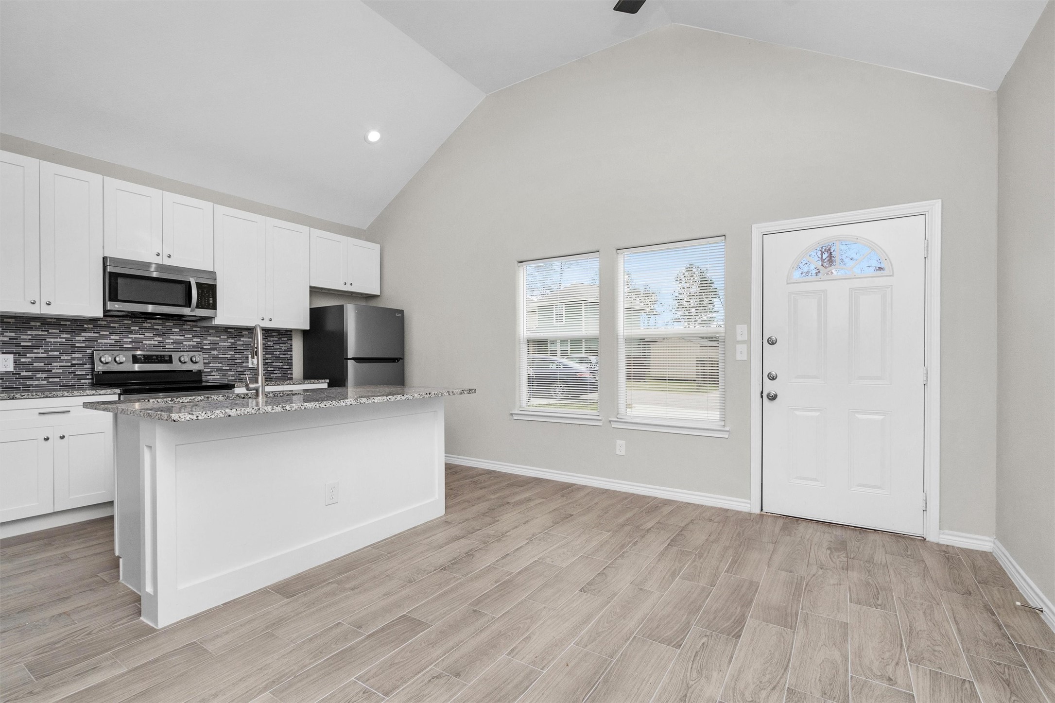 16706 East Hammon Montgomery, TX 77316 - Photo 6 of 26 a kitchen with stainless steel appliances granite countertop a stove top oven a sink and a granite counter tops with wooden floors