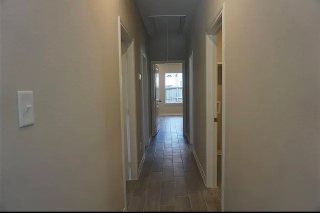 a view of a hallway with wooden floor