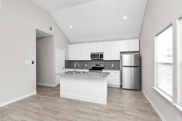 a kitchen with stainless steel appliances a refrigerator and a stove top oven