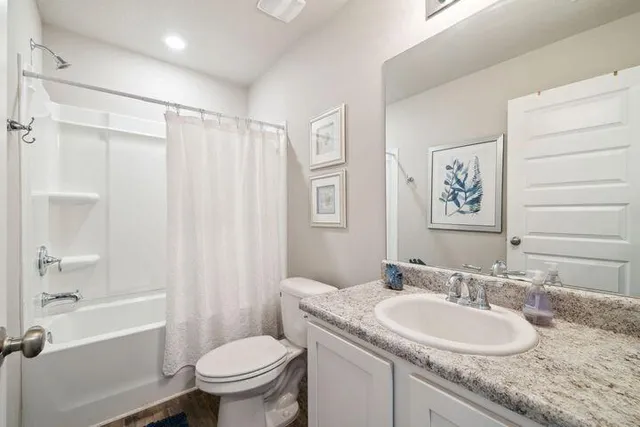 a bathroom with a granite countertop sink toilet and shower