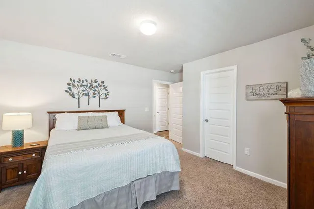 a bedroom with a bed and a lamp