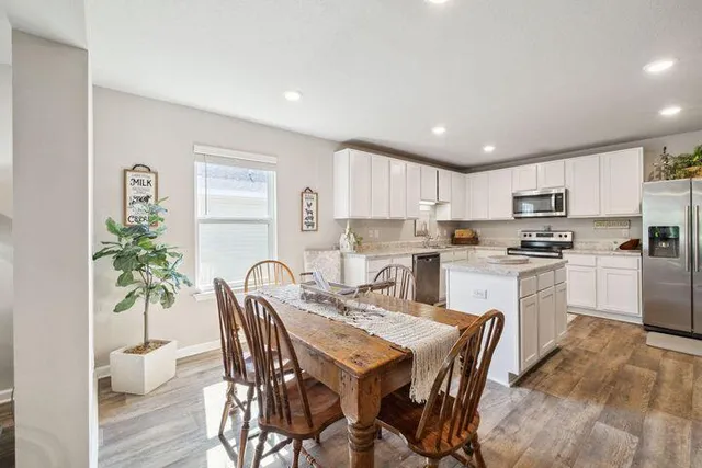a kitchen with granite countertop white cabinets and stainless steel appliances