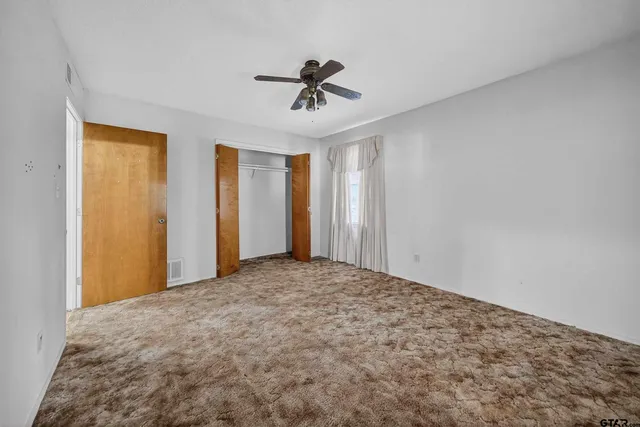 a view of a livingroom with a ceiling fan and window
