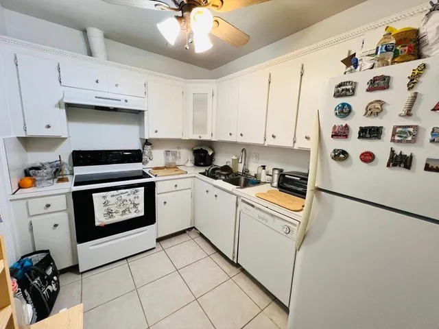 a kitchen with granite countertop a stove a sink and a refrigerator