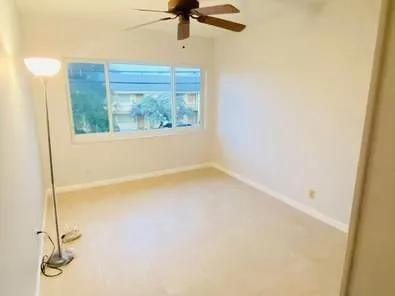 a view of a room with a window and a ceiling fan