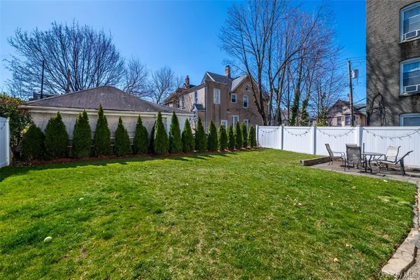a view of a house with backyard and sitting area
