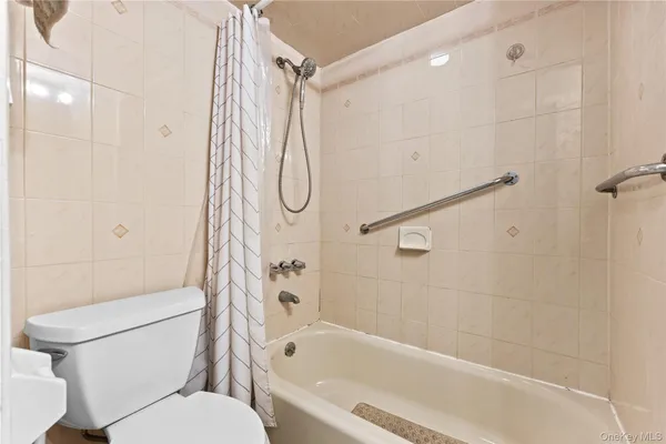 a white toilet sitting next to a bath tub and shower