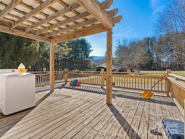 a view of a deck with wooden floor and fence next to a yard