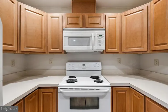 a kitchen with granite countertop white cabinets and white appliances