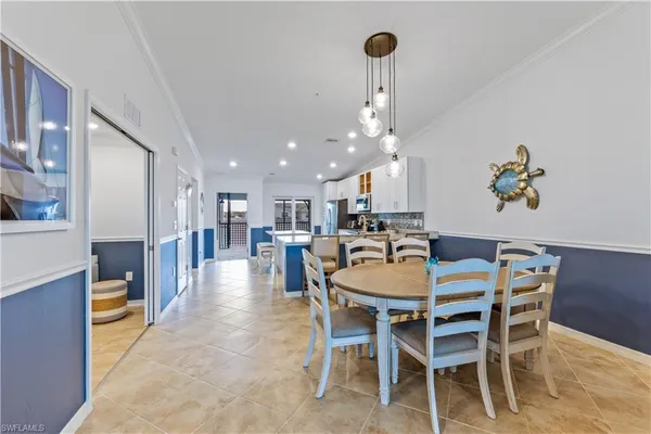 a dining room with furniture a kitchen and chandelier