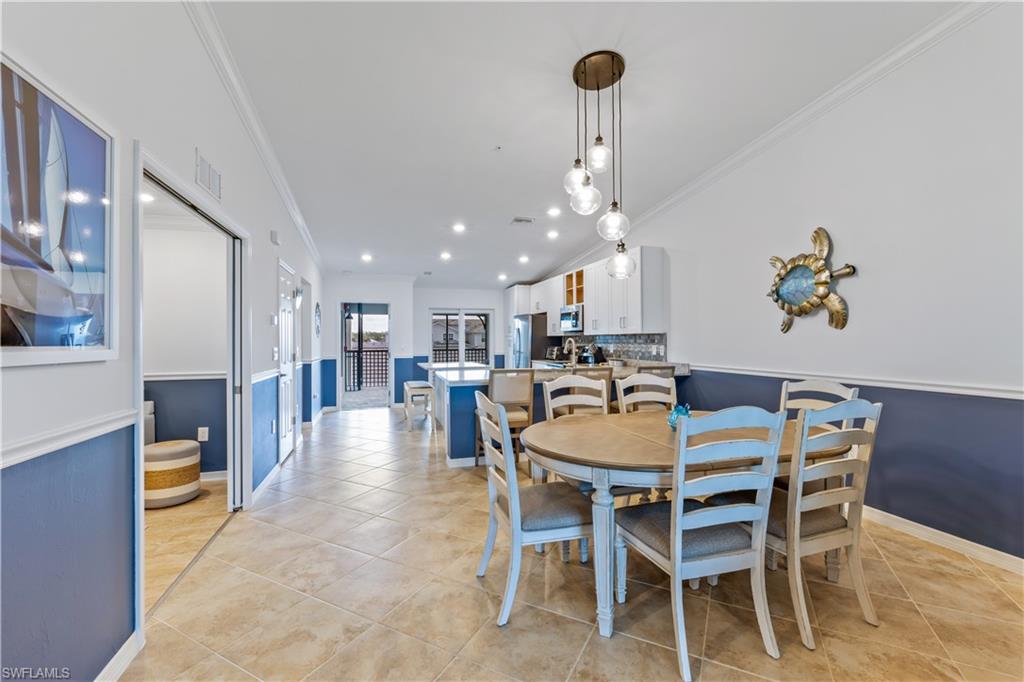 15990 Grassland Lane, Unit 3025 Babcock Ranch, FL 33982 - Photo 12 of 14 a dining room with furniture a kitchen and chandelier