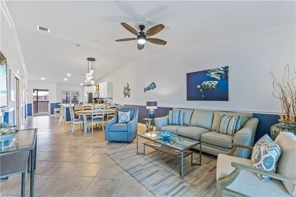a living room with furniture kitchen view and a chandelier
