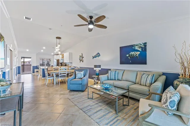 a living room with furniture kitchen view and a chandelier