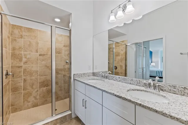 a bathroom with a granite countertop sink a mirror and a shower