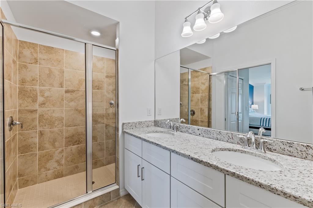 15990 Grassland Lane, Unit 3025 Babcock Ranch, FL 33982 - Photo 7 of 14 a bathroom with a granite countertop sink a mirror and a shower