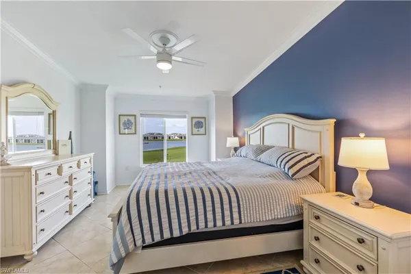 a bedroom with a large bed and a chandelier