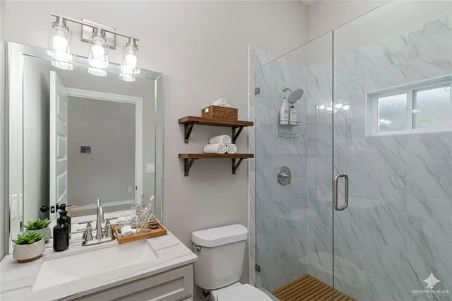 a bathroom with a sink a toilet and shower